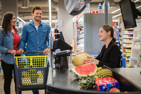 Young couple buying goods in a grocery storeの写真素材