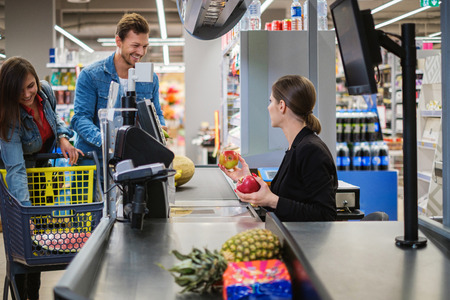 Young couple buying goods in a grocery storeの写真素材