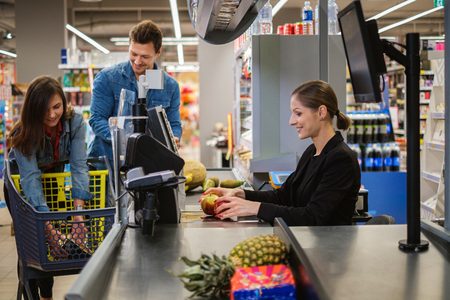 Young couple buying goods in a grocery storeの写真素材