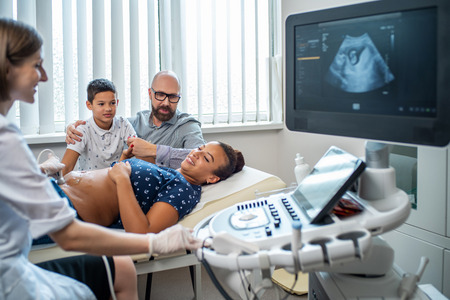 Pregnant woman and her family on utltrasonographic examination at hospitalの写真素材