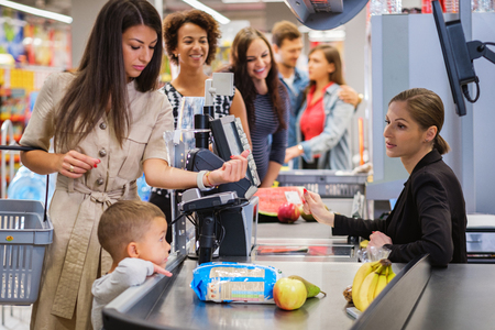 Woman paying with a smart watches in a grocery storeの写真素材