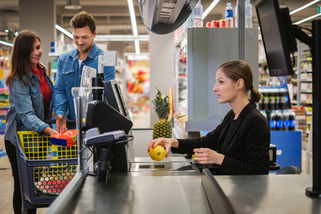Young couple buying goods in a grocery storeの写真素材