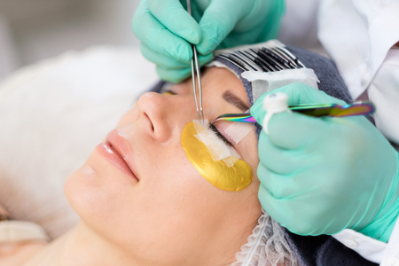 Procedure of eyelash extension in salon by cosmetician
