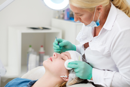 Beautician performing henna brows correction