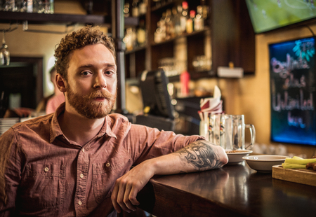 Man tasting fresh beer in a pubの写真素材