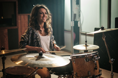 Woman playing drums during music band rehearsalの写真素材