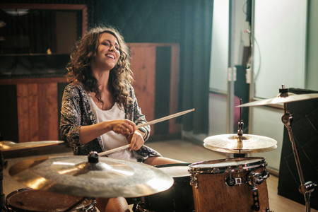 Woman playing drums during music band rehearsalの写真素材