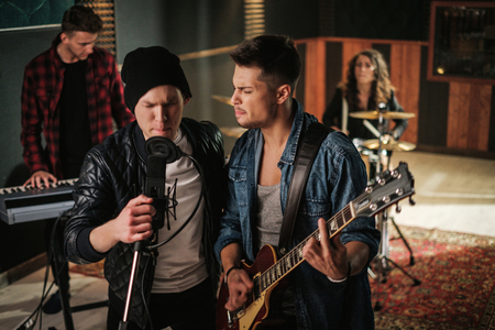 Music band having rehearsal in a studioの写真素材
