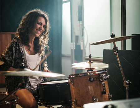 Woman playing drums during music band rehearsalの写真素材