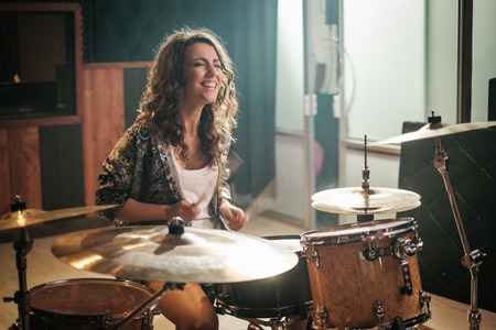 Woman playing drums during music band rehearsalの写真素材