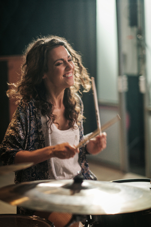 Woman playing drums during music band rehearsalの写真素材