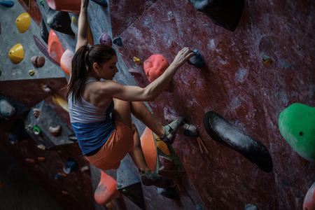 Athletic woman practicing in a bouldering gymの写真素材