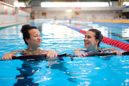 Multiracial couple attending water aerobics class in a swimming poolの写真素材