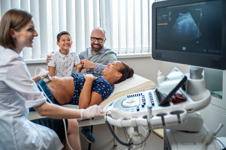 Pregnant woman and her family on utltrasonographic examination at hospitalの写真素材