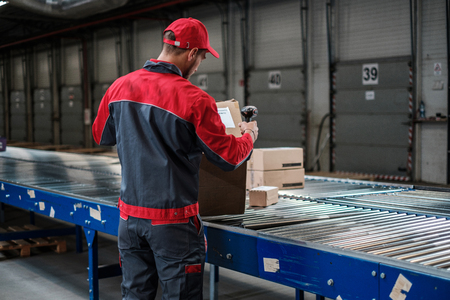 Warehouse worker working on a conveyor lineの写真素材