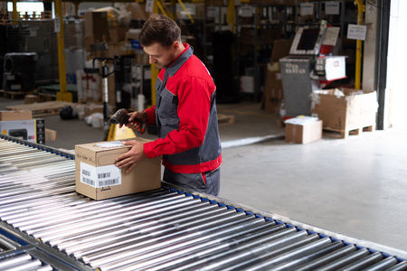Warehouse worker working on a conveyor lineの写真素材