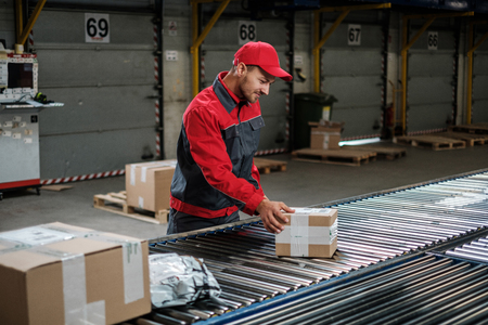 Warehouse worker working on a conveyor lineの写真素材