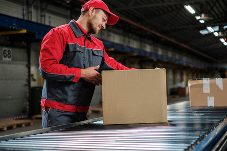 Warehouse worker working on a conveyor lineの写真素材