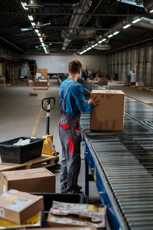 Warehouse worker working on a conveyor lineの写真素材