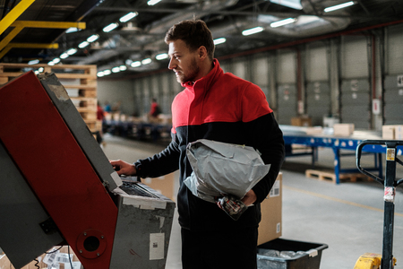 Courier picks up package on a warehouseの写真素材