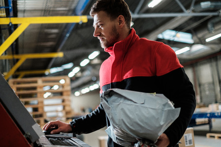 Courier picks up package on a warehouseの写真素材