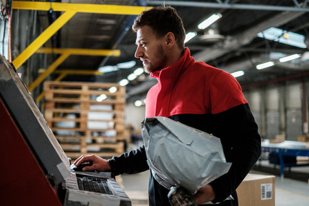 Courier picks up package on a warehouseの写真素材