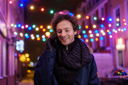 Man with a mobile phone on a cold winter eveningの写真素材