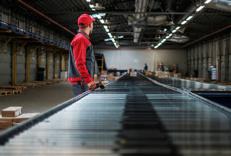 Warehouse worker working on a conveyor lineの写真素材