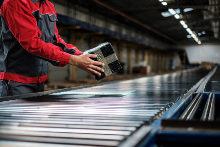 Warehouse worker working on a conveyor lineの写真素材