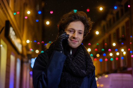 Man with a mobile phone on a cold winter eveningの写真素材