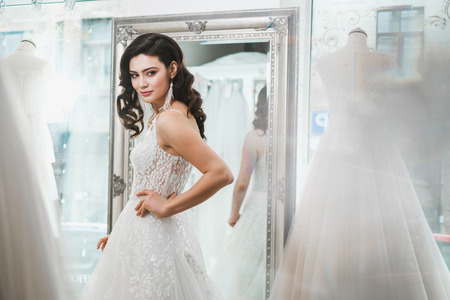 Beautifu bride choosing wedding dress in a wedding salonの写真素材