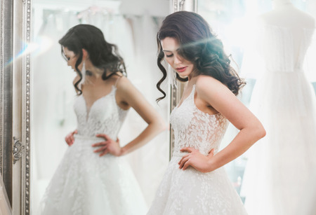 Beautifu bride choosing wedding dress in a wedding salonの写真素材