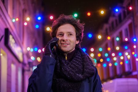 Man with a mobile phone on a cold winter eveningの写真素材