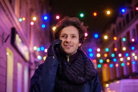 Man with a mobile phone on a cold winter eveningの写真素材