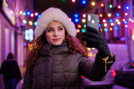 Woman making selfie a cold winter eveningの写真素材