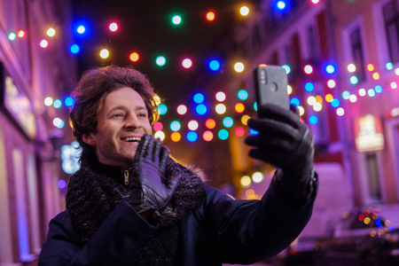 Man making selfie on a cold winter eveningの写真素材