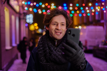 Man making selfie on a cold winter eveningの写真素材