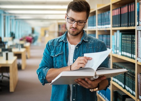 Young woman choosing book in public libraryの写真素材
