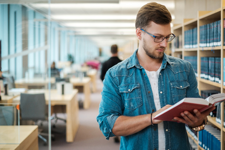 Young woman choosing book in public libraryの写真素材