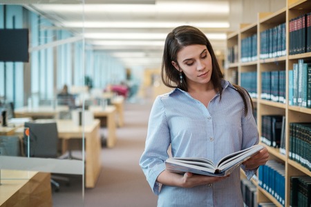 Young woman choosing book in public library.の写真素材
