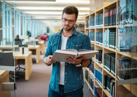 Young woman choosing book in public libraryの写真素材