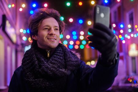 Man making selfie on a cold winter eveningの写真素材