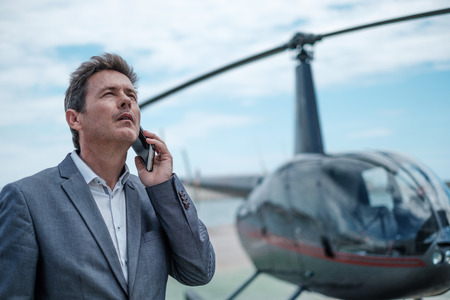 Businessman standing near private helicopterの写真素材