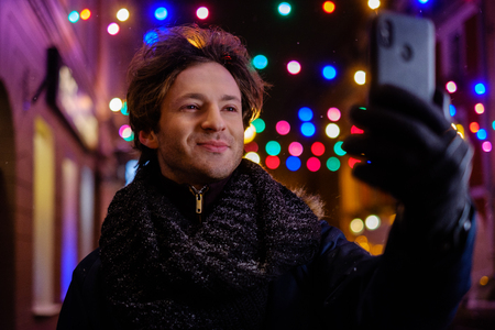 Man making selfie on a cold winter eveningの写真素材