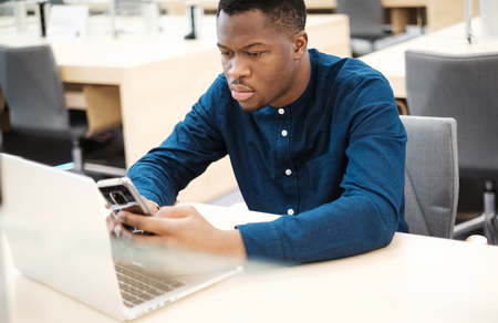 Young man working on a laptop in public libraryの写真素材
