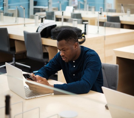 Young man working on a laptop in public libraryの写真素材