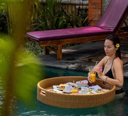 Woman enjoying floating breakfast at Baliの写真素材