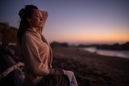 Woman enjoying sunset near oceanの写真素材