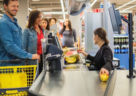 Couple buying goods in a grocery storeの写真素材