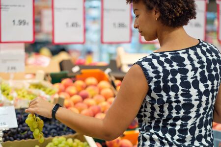 Woman choosing fruits in a grocery storeの写真素材